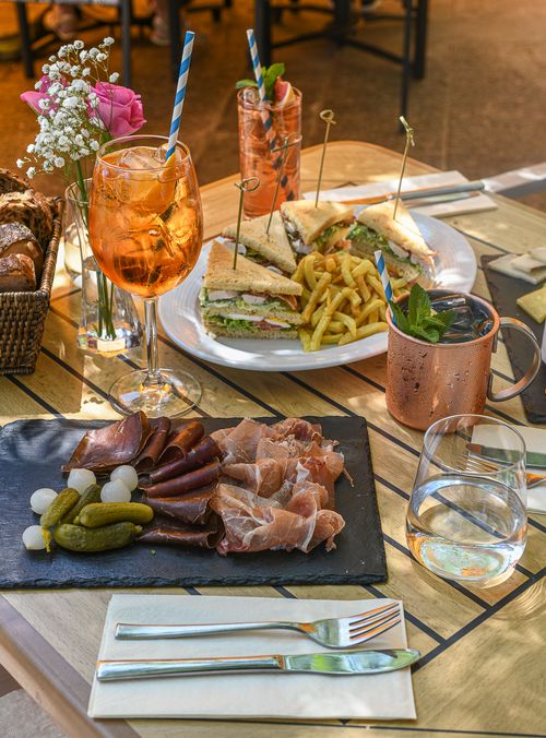 Deux assiettes de plats avec des verres de vin et d'eau sur une table extérieure.