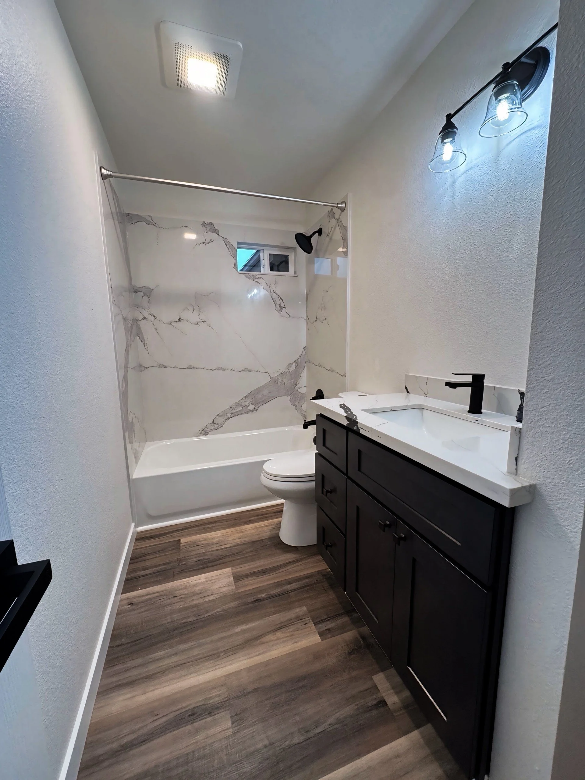 Modern bathroom remodel featuring a clean, functional design with updated fixtures and finishes by 4 Edges Construction.