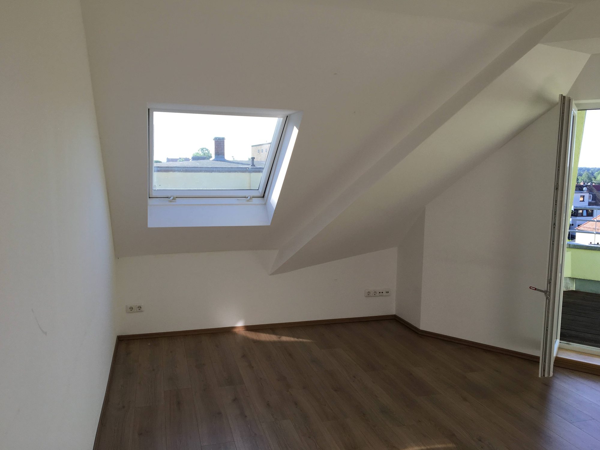 Wohnzimmer mit Dachfenster und Zugang zur Loggia