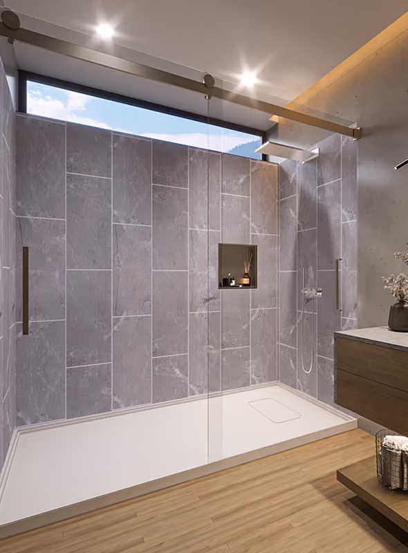 Modern walk-in shower with gray tiled walls, glass doors, wood floor, and built-in shelf.