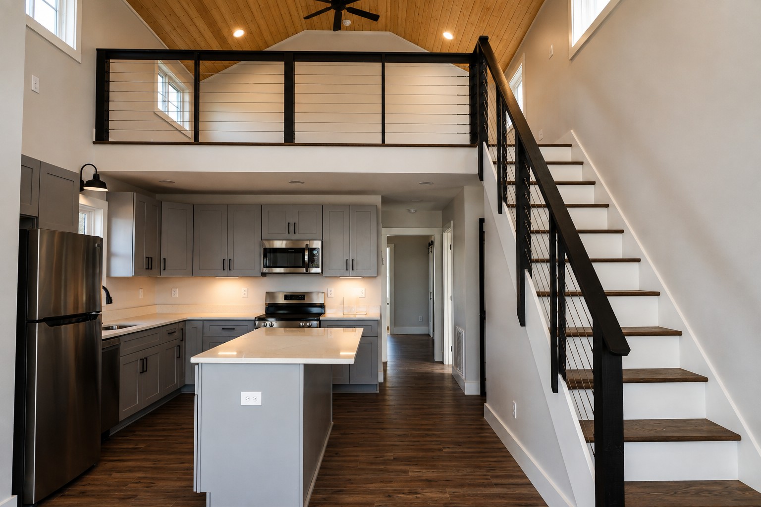 Open-concept interior of a Retreat at Water's Edge cabin with a loft overlook and staircase.