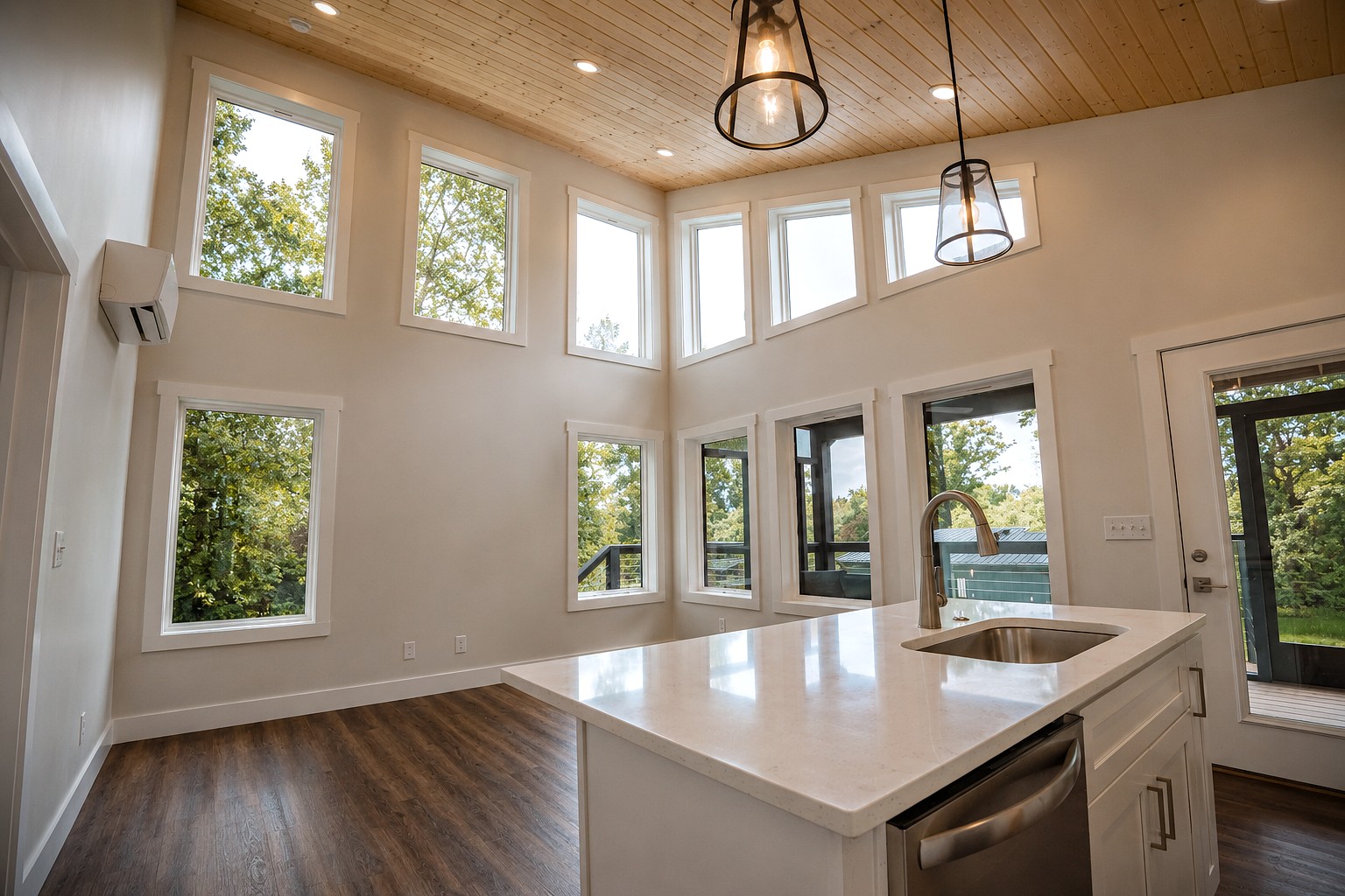 Open kitchen with a white island and wood plank ceiling inside a Retreat at Water's Edge cabin.