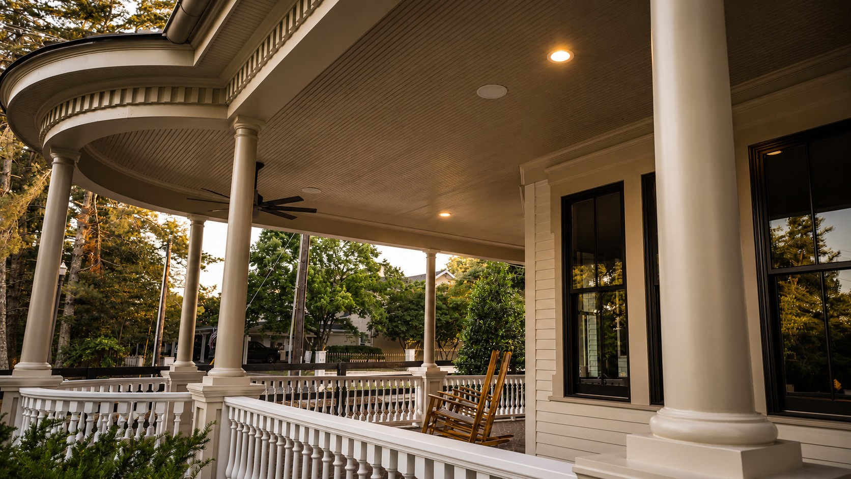 Covered wraparound porch with white columns and rocking chairs at Magnolia Hall, 1835 William Campbell Court.
