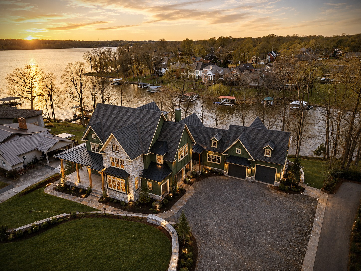 Hannah Custom Homes lake house glowing at sunset with docks and boats along the shoreline.