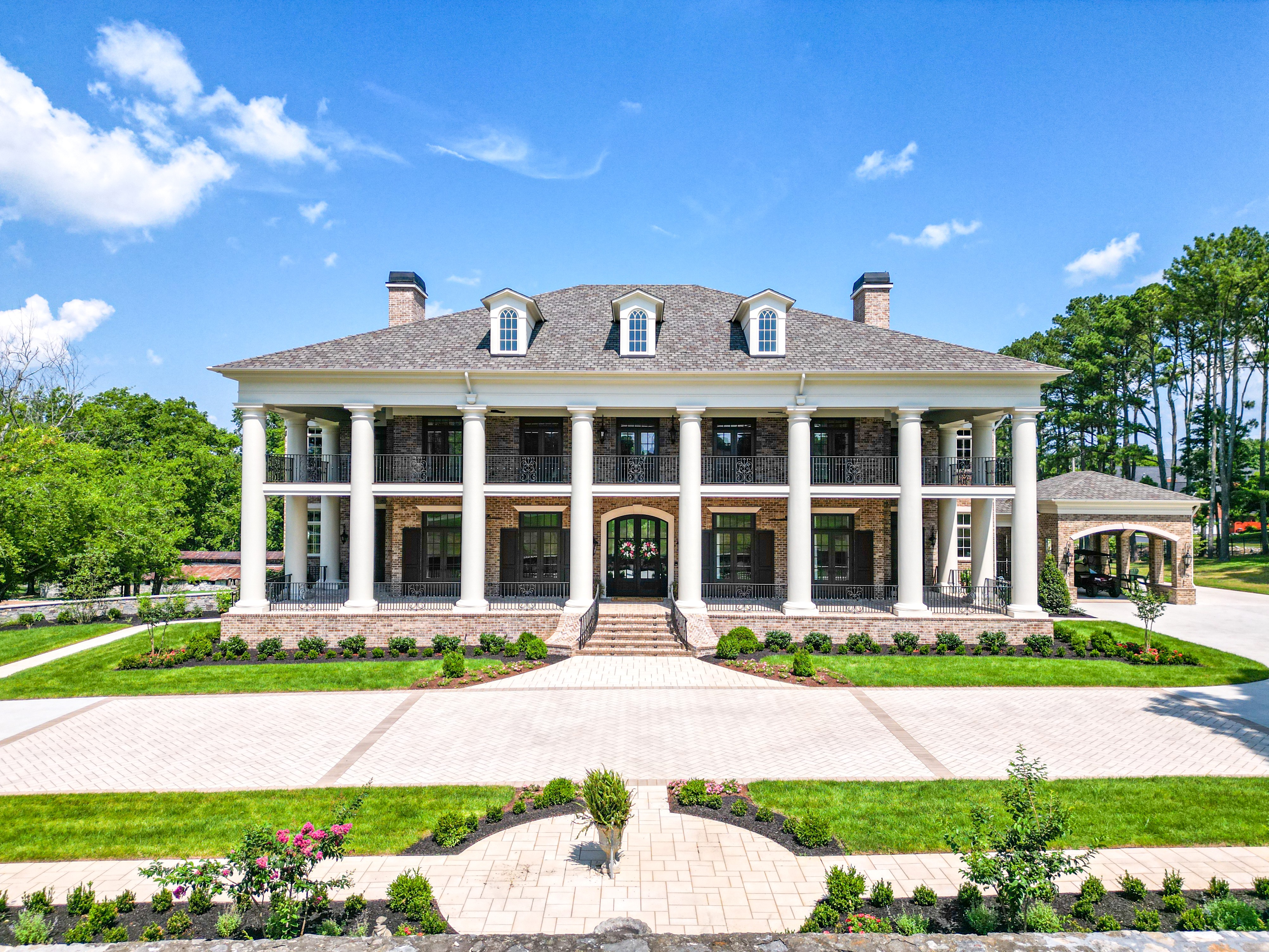 Brick colonial home built by Hannah Custom Homes with tall white columns and a symmetrical facade.