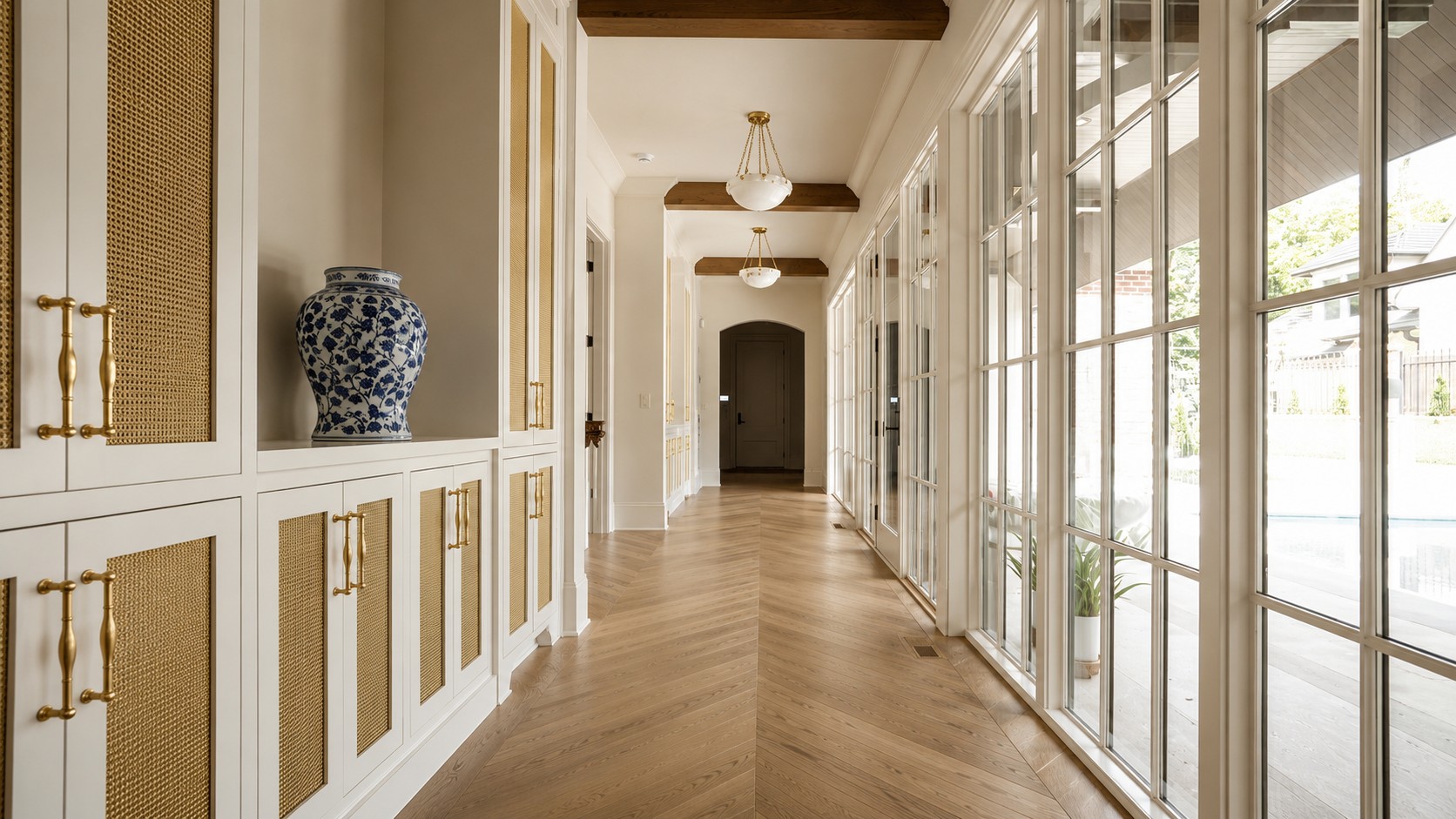 Gallery hallway at Magnolia Hall with herringbone floors and a wall of windows.