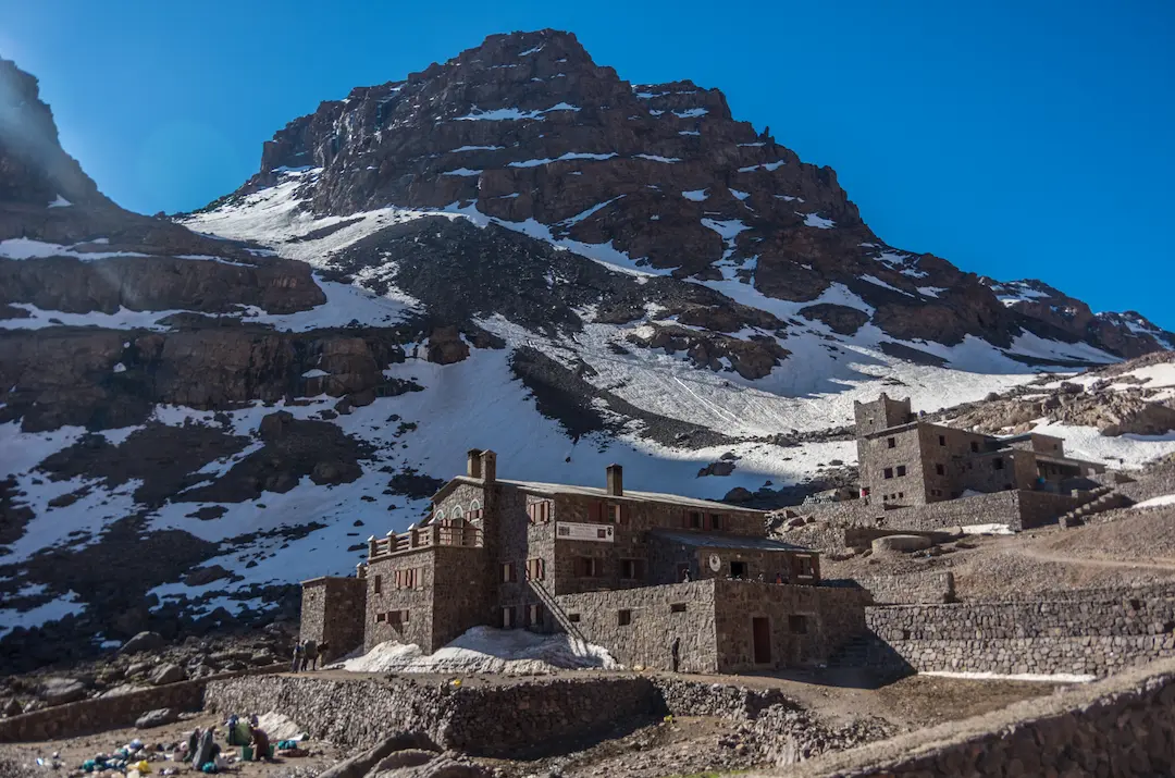 The high-altitude stone shelters of the Toubkal Refuge (3,207m), the primary base camp used by trekkers preparing to summit Mount Toubkal.