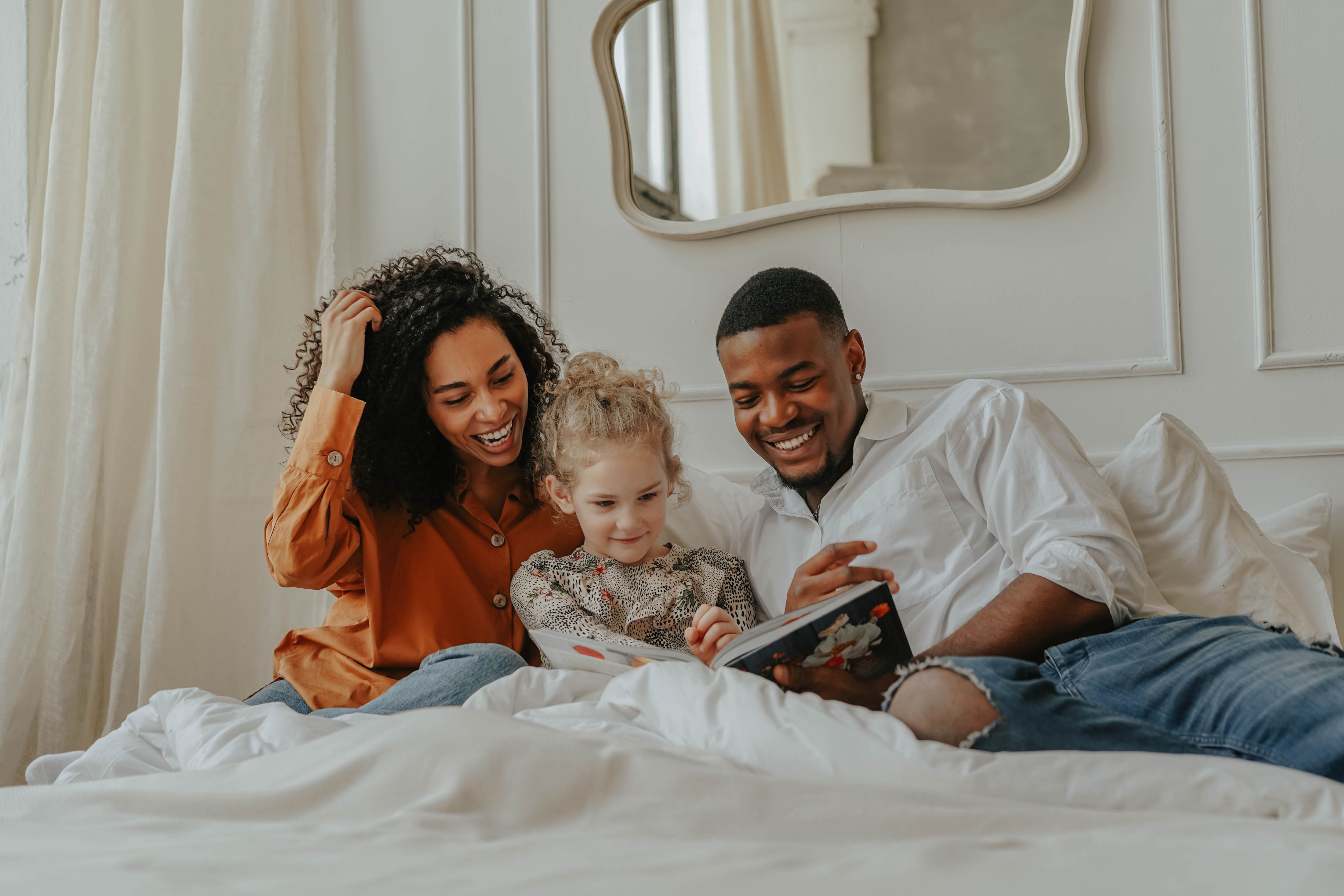 Family laughing on bed stock image