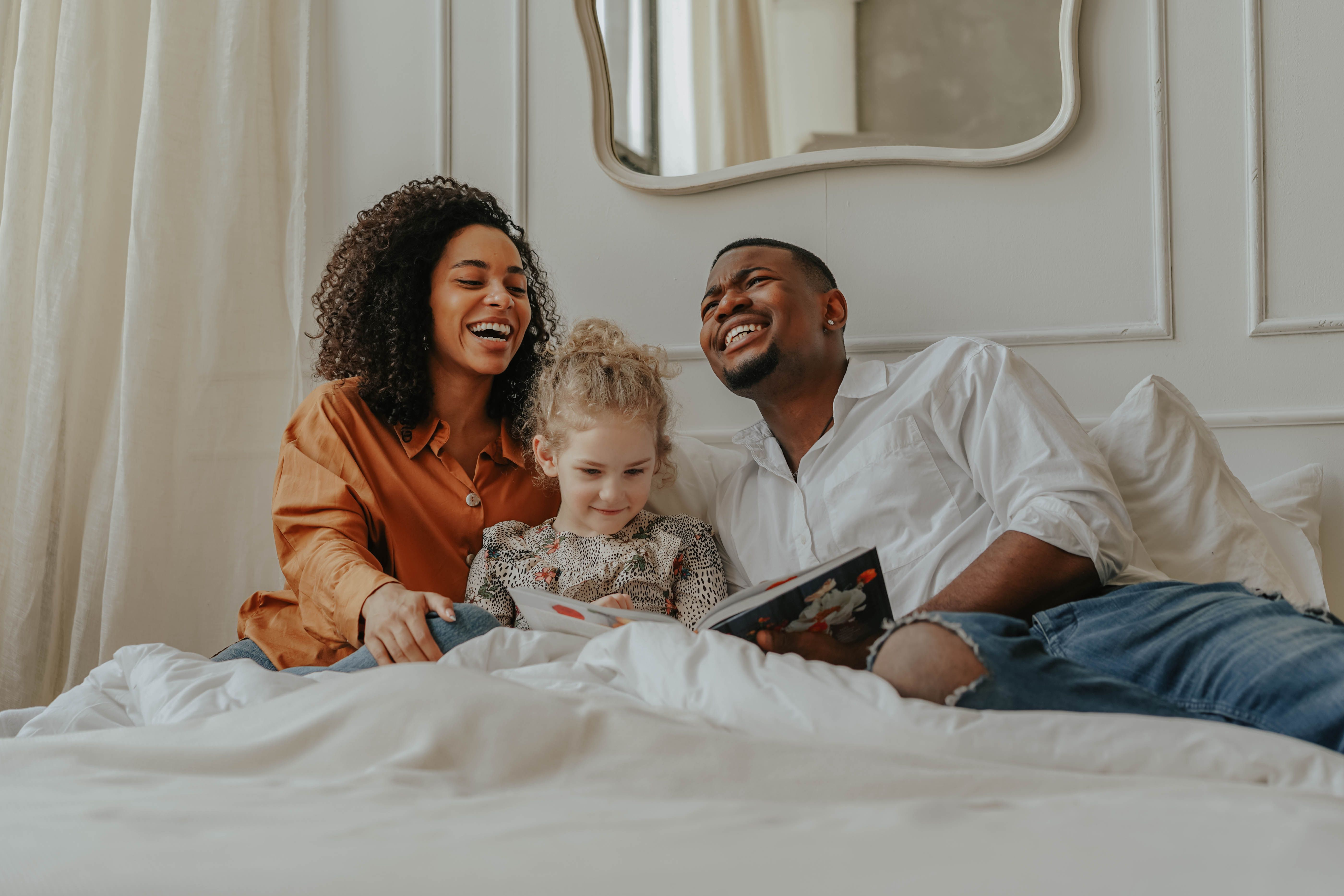Family laughing on bed stock image