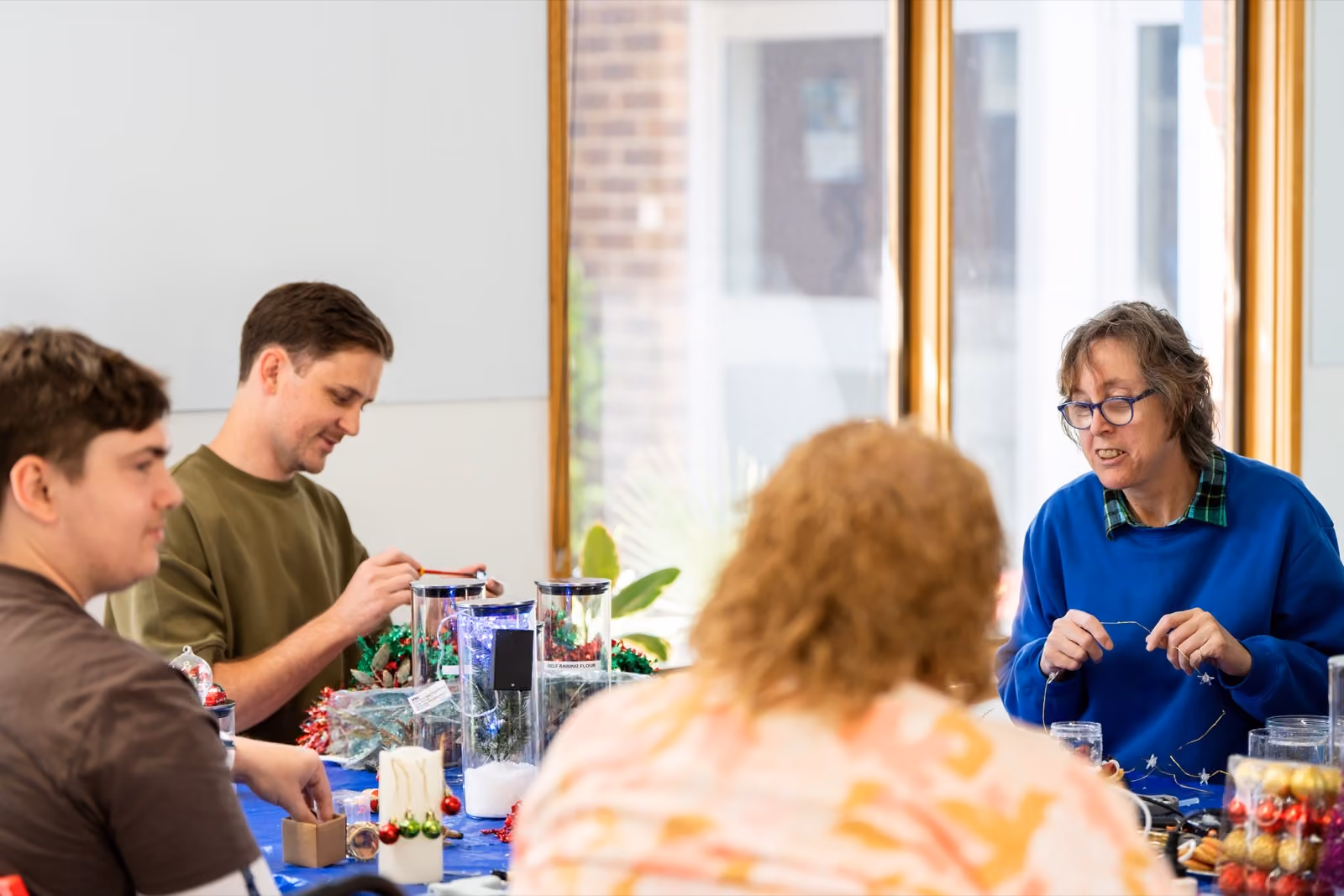 A group taking part in a craft activity together with a support worker