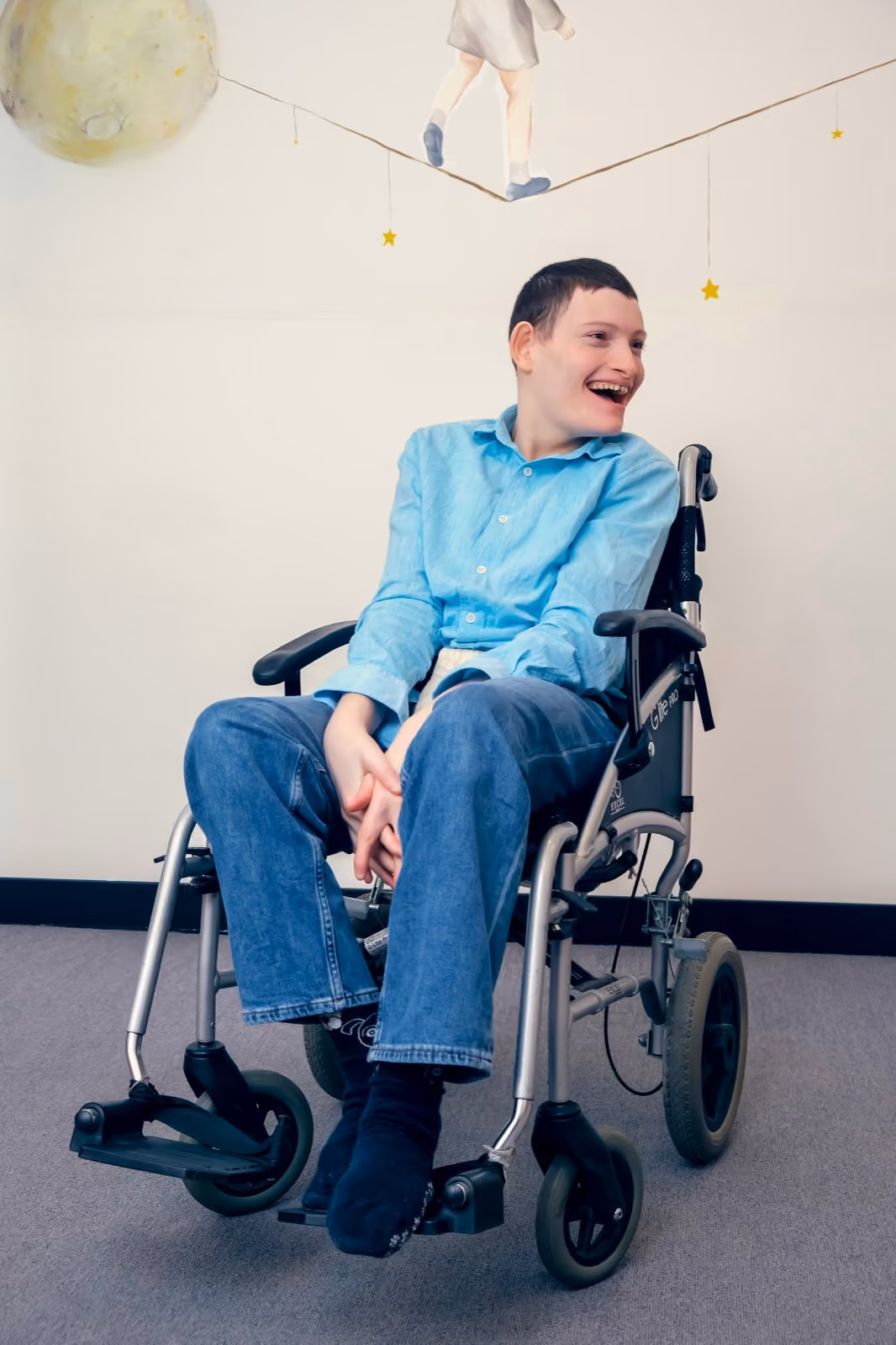 A young man in a wheelchair, laughing and relaxed