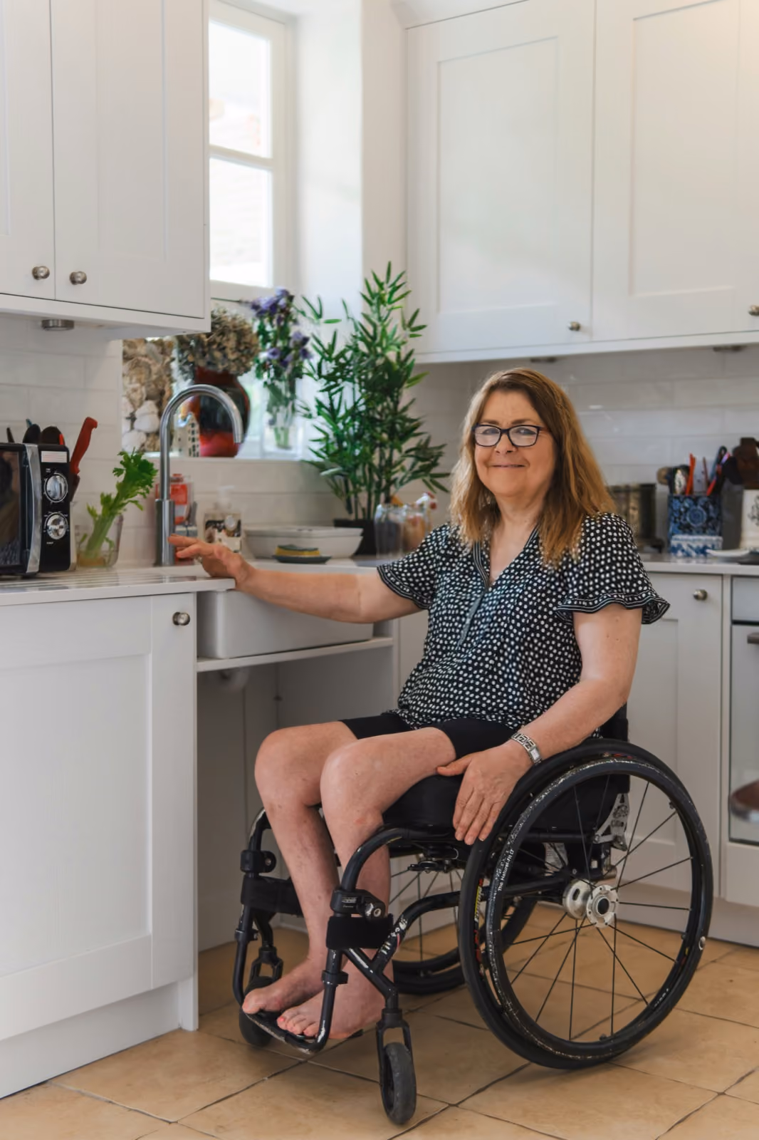 A participant at home in her kitchen, smiling