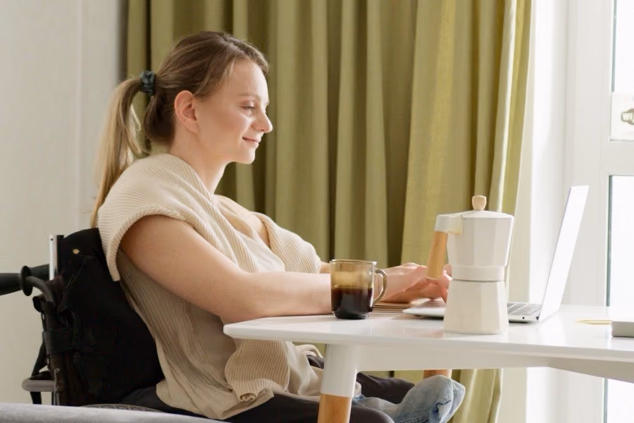A participant working at her laptop at home by the window