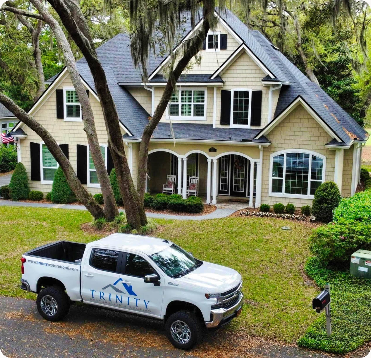 A Trinity Restoration and Roofing truck parked outside a completed residential job