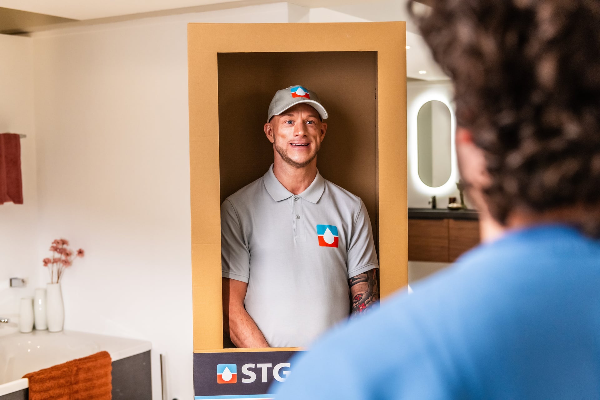 Vakman in een STG-doos in de badkamertoonzaal