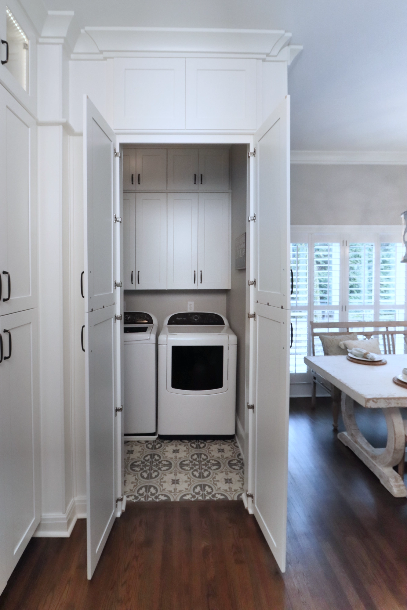 Laundry room hidden access in kitchen cabinetry