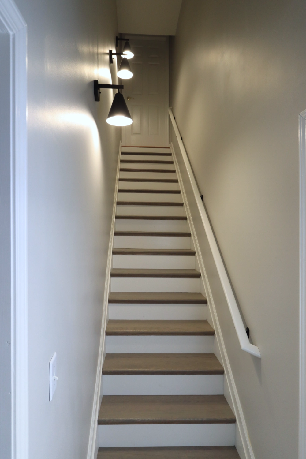 Stairway with new flooring and decorative wall sconces