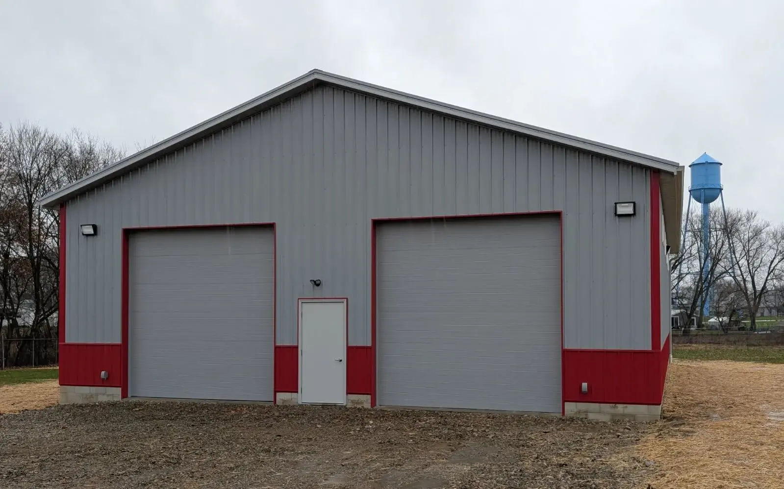 gray and red garage with water tank in back