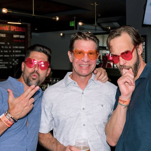 Three SmarterDx teammates in matching red sunglasses at a team happy hour