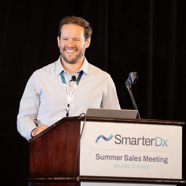 A teammate presenting at the SmarterDx Summer Sales Meeting in Boulder