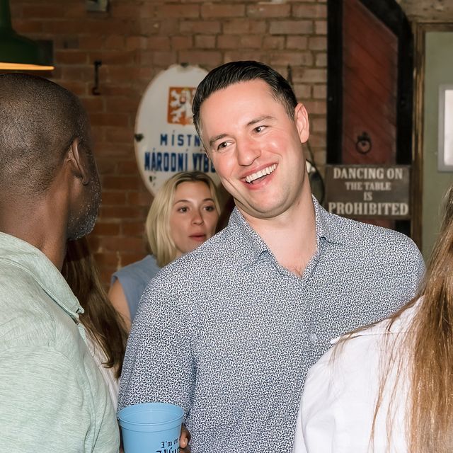 Two teammates laughing together at an offsite reception