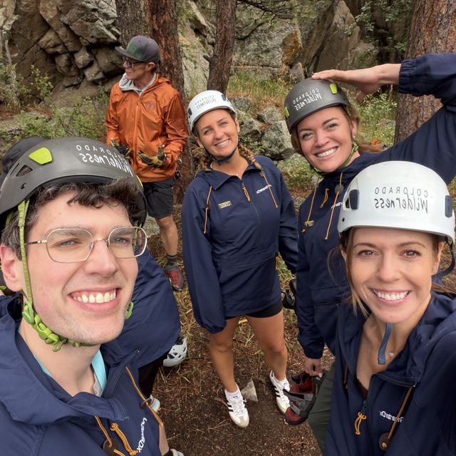 Teammates in climbing helmets on a team outing in the foothills