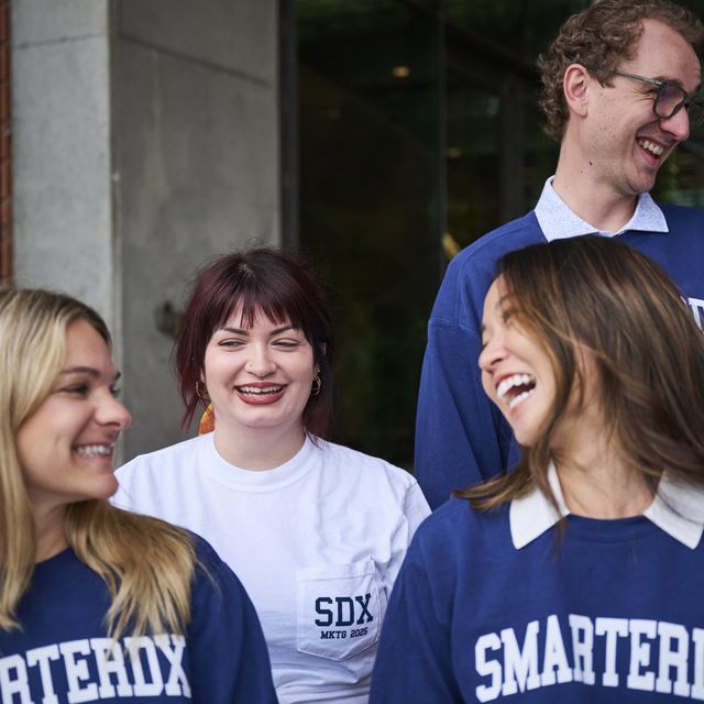 Teammates in SmarterDx sweatshirts laughing together