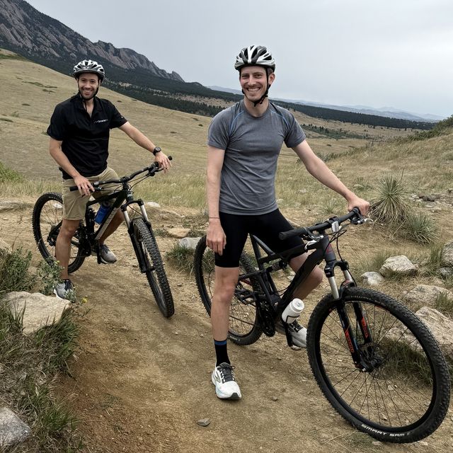 Two teammates with mountain bikes at the trailhead