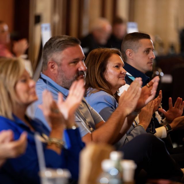 Teammates applauding during a company session