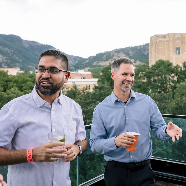 Two teammates talking on the rooftop deck