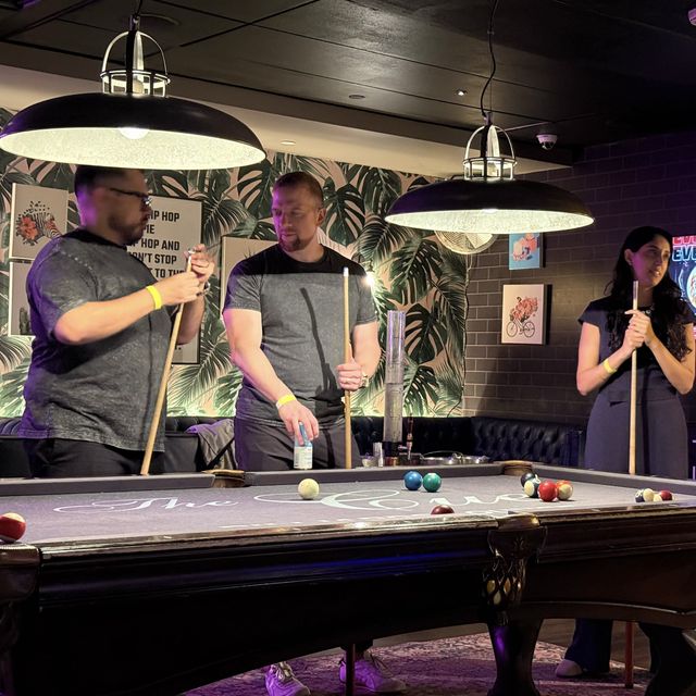 Teammates playing pool at a team night out