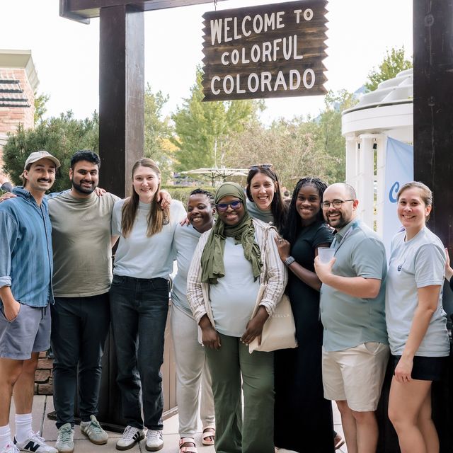 The team by a Welcome to Colorful Colorado sign