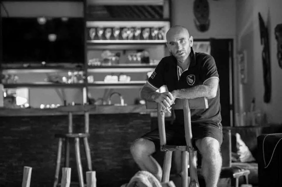 Homme assis dans une cuisine, photo en noir et blanc