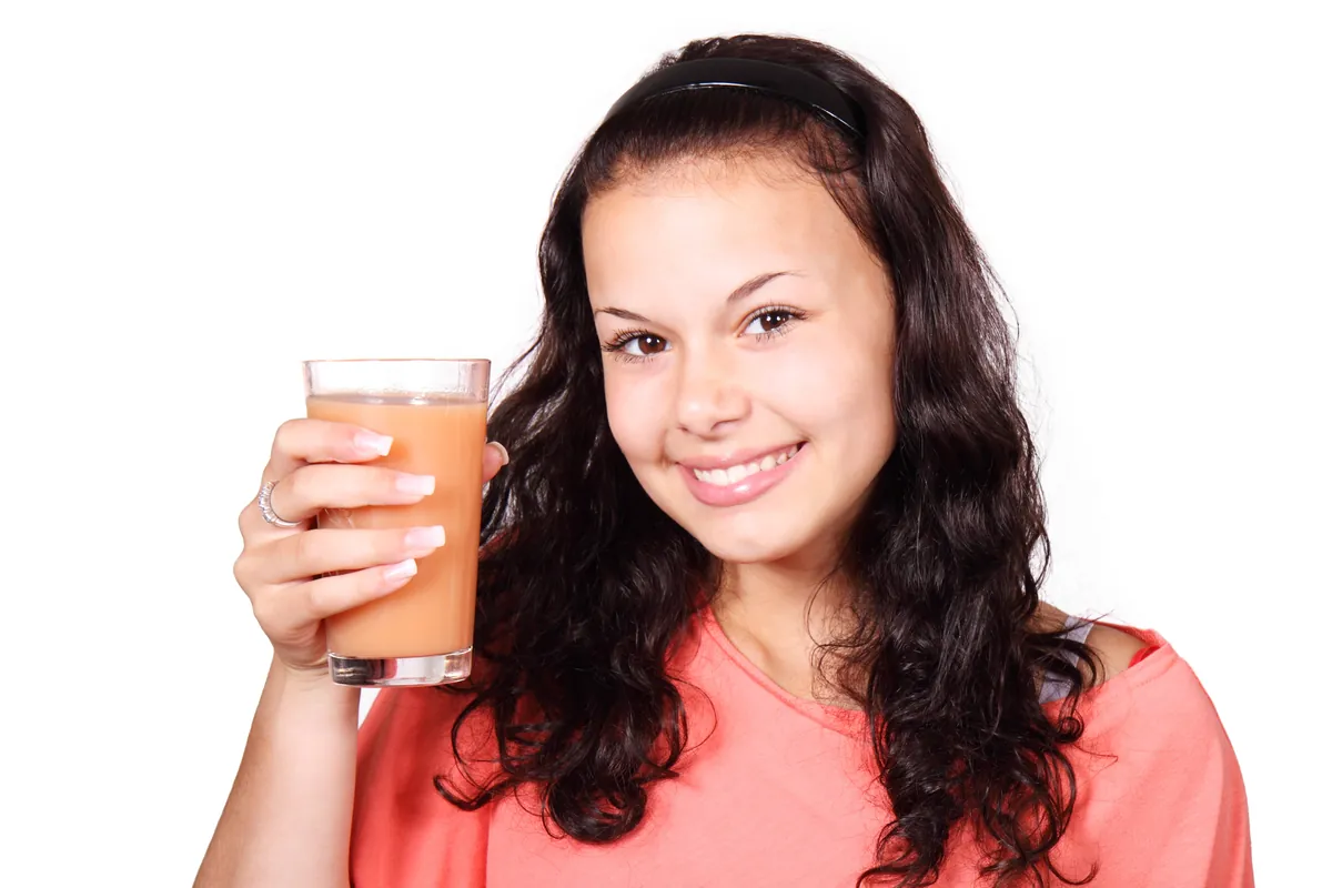 Jeune femme souriante avec un verre de jus