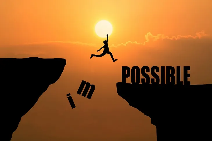 Silhouette qui saute entre deux falaises, le mot IMPOSSIBLE devient POSSIBLE