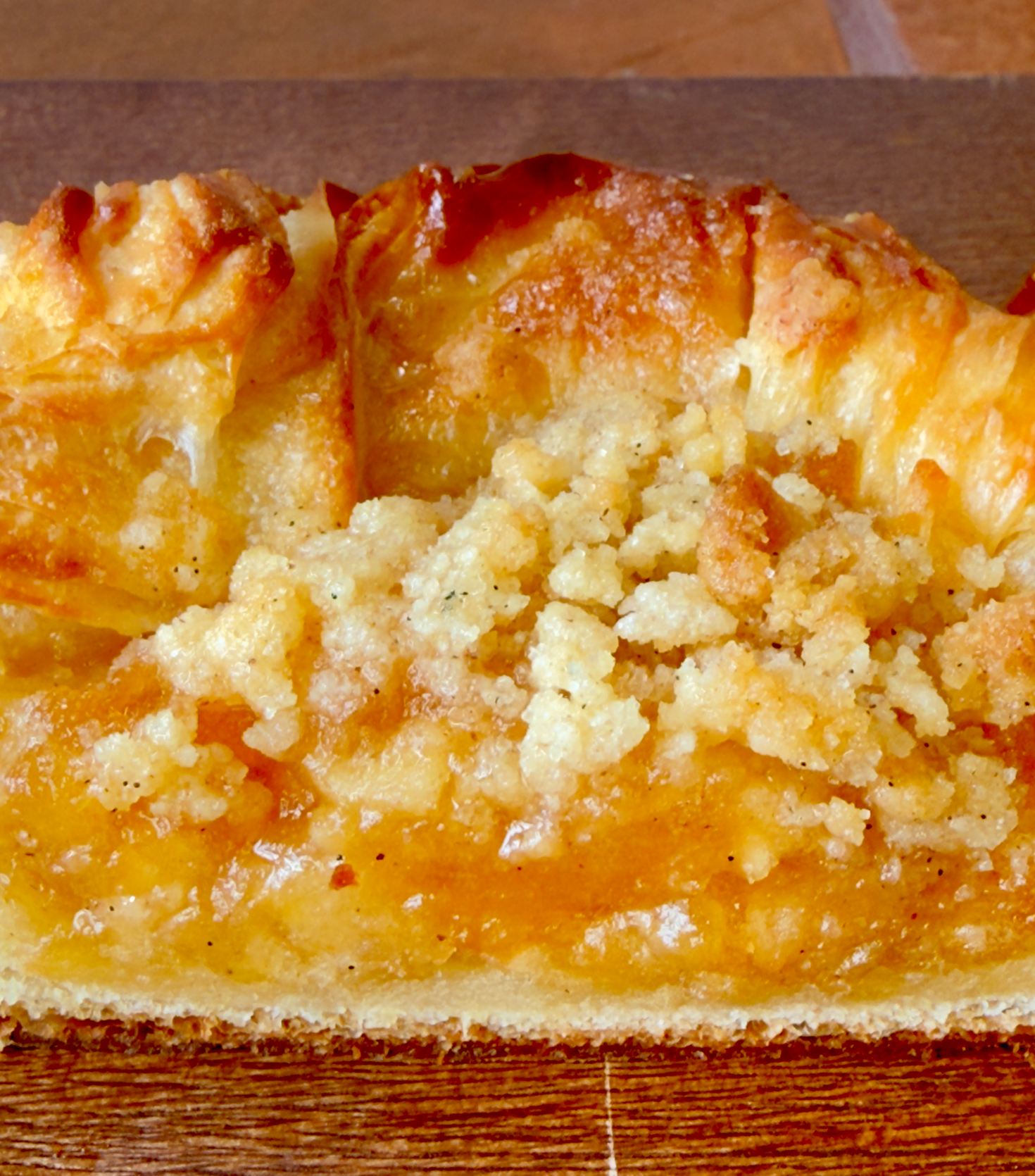 Close-up of an apple crumble danish with a golden streusel topping