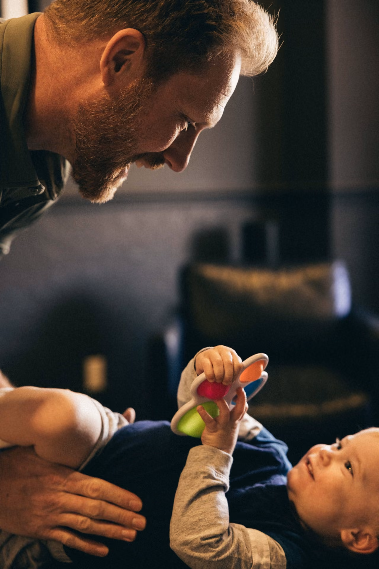 A clinician guiding an infant through a developmental movement assessment with a toy