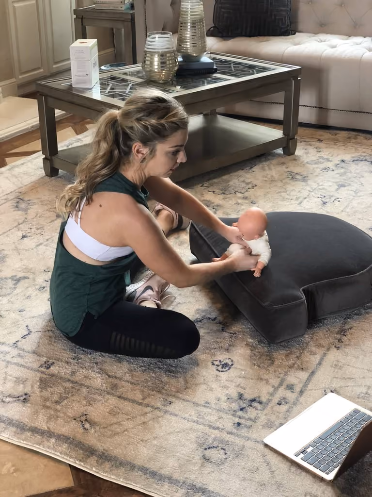 Dr. Emily Heisey working with an infant on the floor while filming a Building Blocks lesson