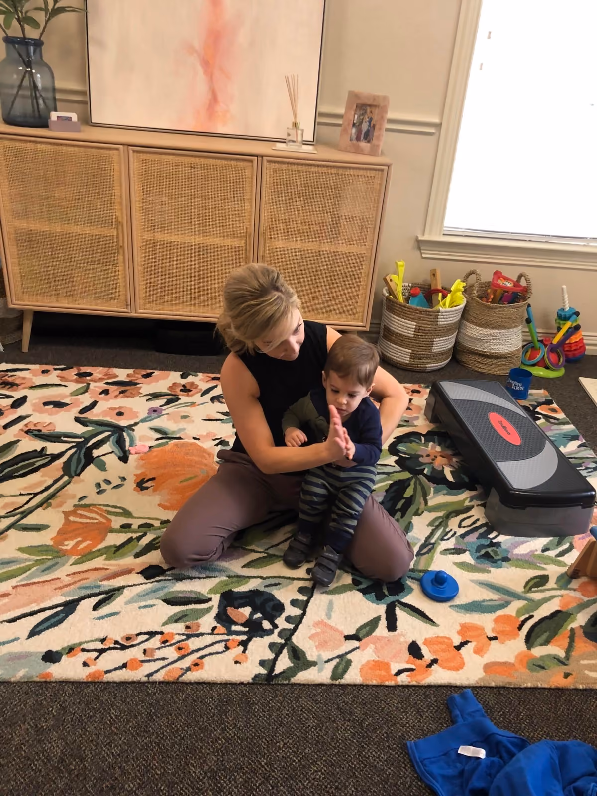 Dr. Emily Heisey working on gross motor play with a toddler on the clinic floor