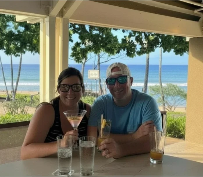 Kyle and Ashley at an oceanfront table at golden hour.