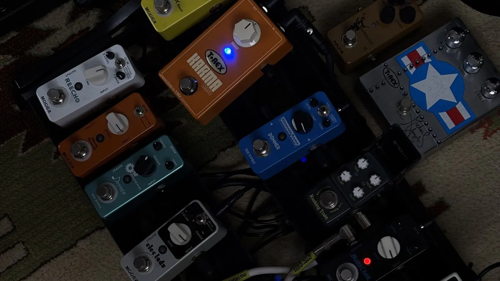 A guitar effects pedalboard, a grid of colourful stompboxes