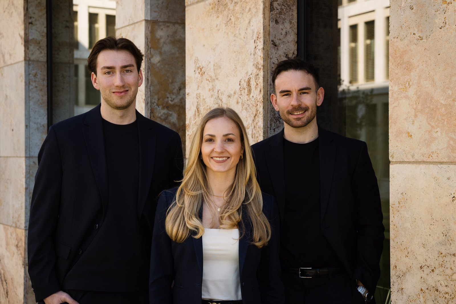 Drei Teammitglieder von FinanzErfahrungen vor dem Bürogebäude