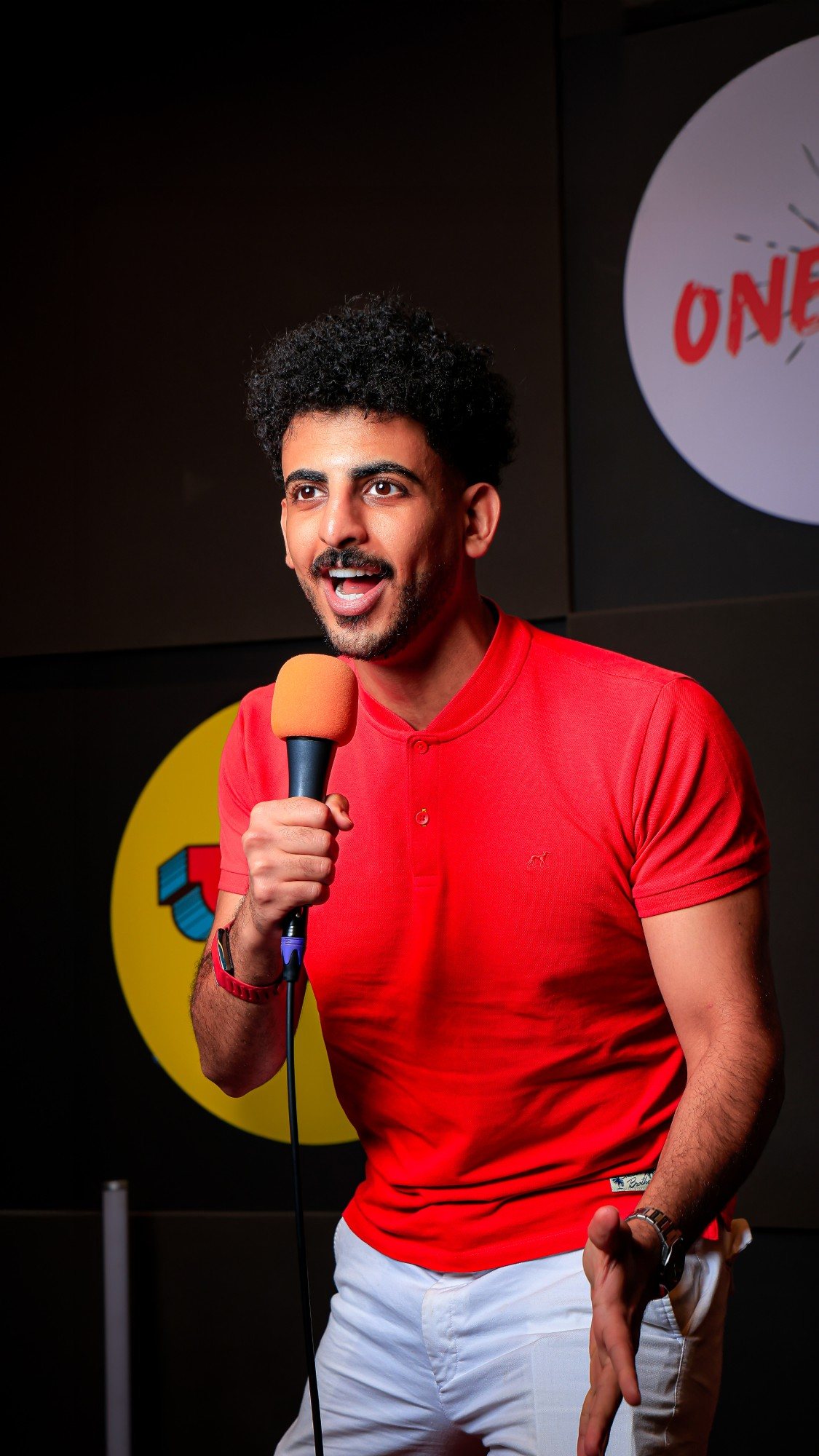 Abdullah Jamil performing stand-up comedy with a microphone