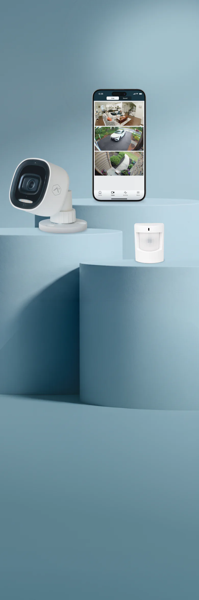 Brinks Home outdoor security camera, a smartphone showing three live camera feeds, and a motion sensor, displayed on studio pedestals