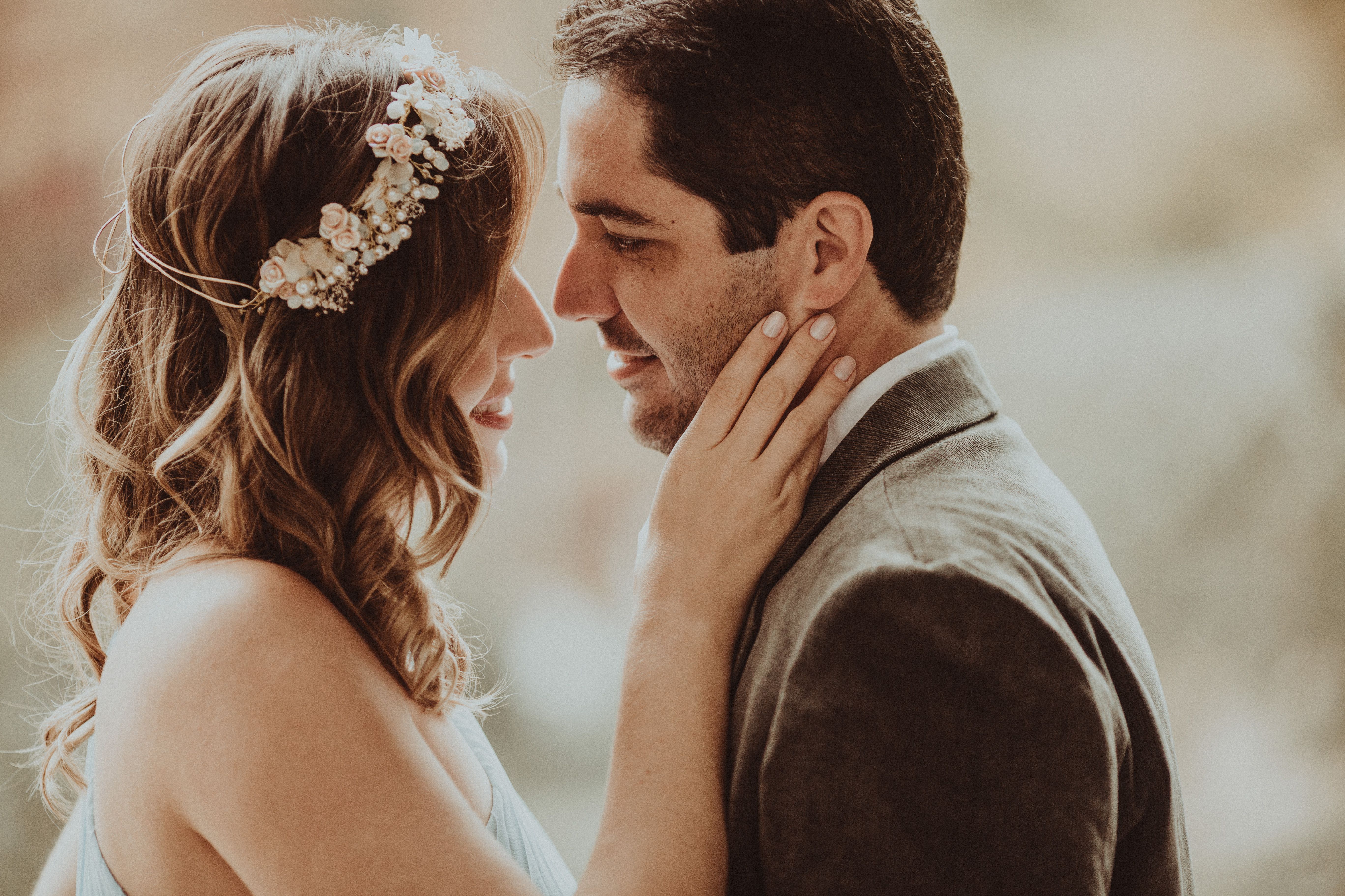 Couple de mariés échangeant un regard devant leur photographe lors d'une réception élégante