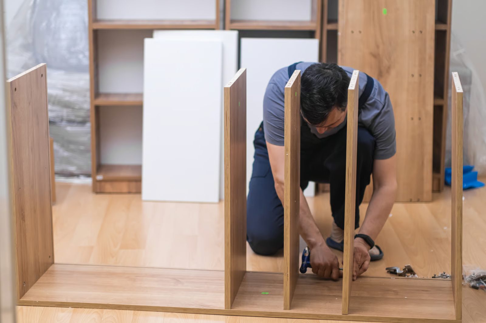 Shelving being assembled and mounted to a wall