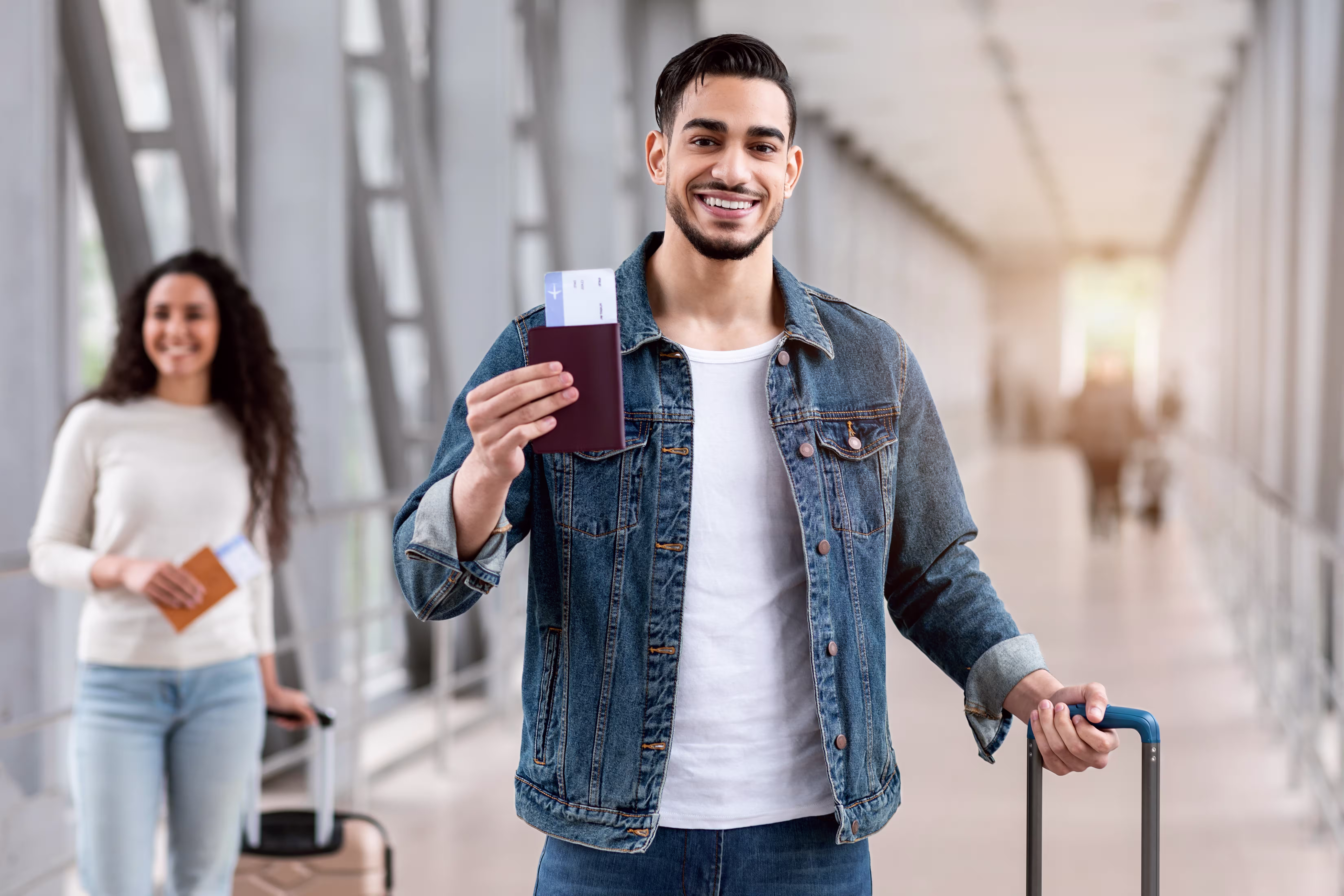 Man holding a passport in an airport terminal, subclass 309 offshore partner visa