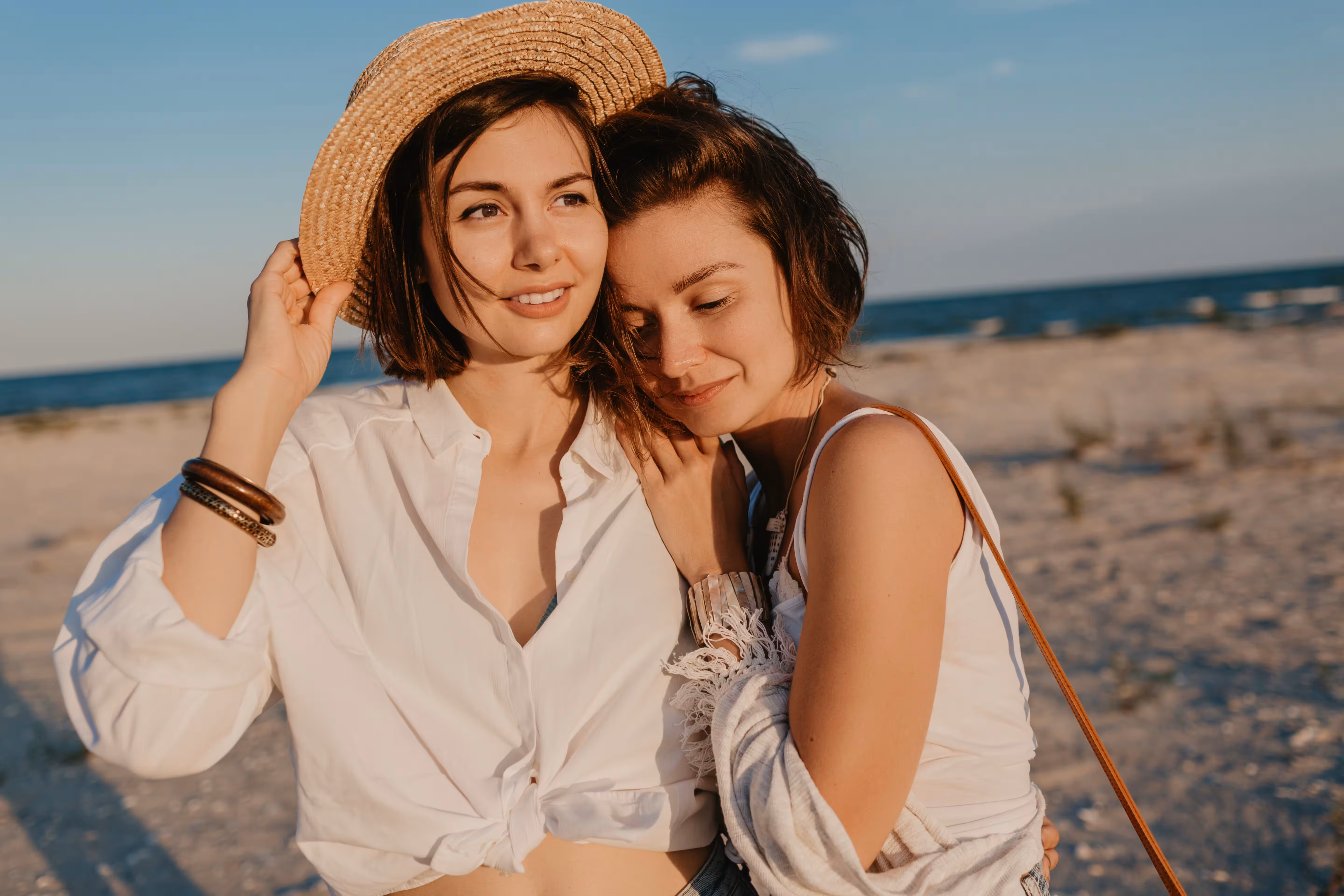 Two women embracing on a beach, same sex partner visa evidence