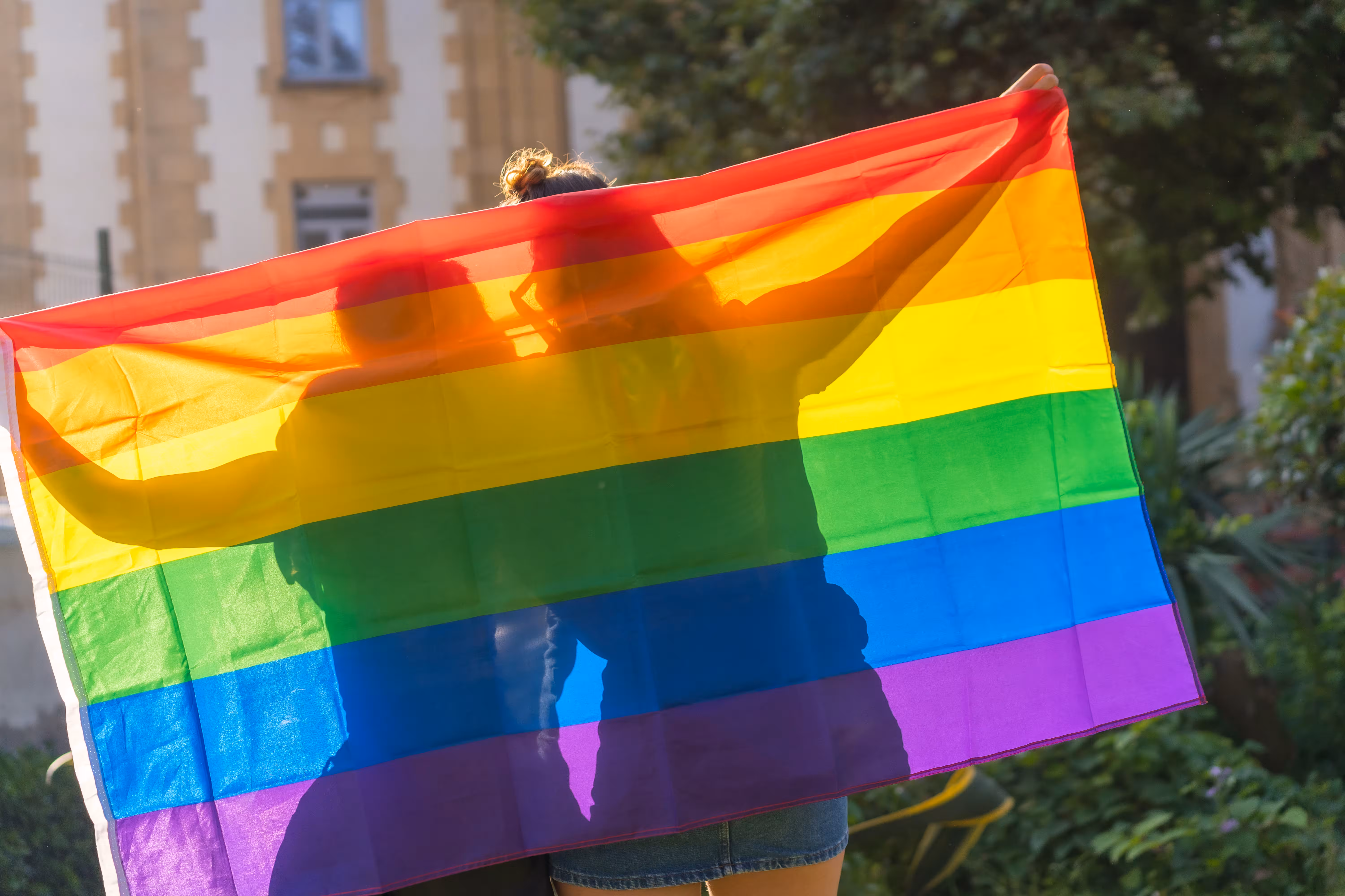 Person holding up a large rainbow flag, LGBTIQ+ partner visa evidence