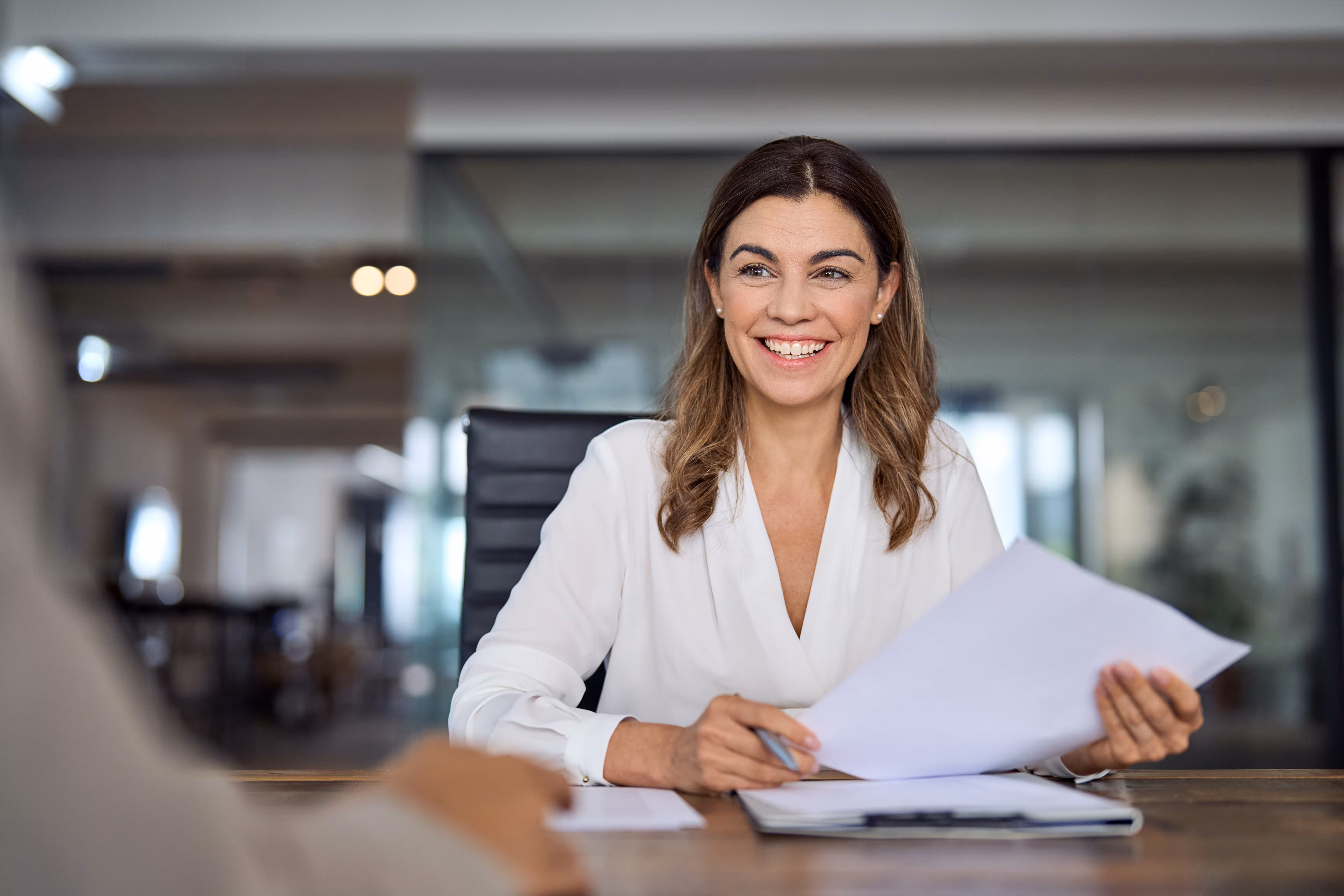 Woman reviewing documents at a desk, relationship evidence after a sponsorship waiver